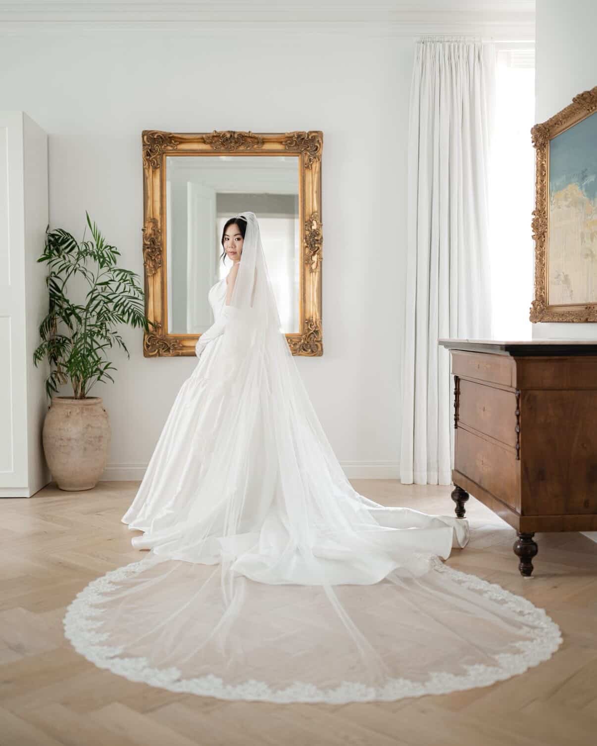 Bride Hanna in her gown and cathedral veil, bridal makeup by Tian Soon