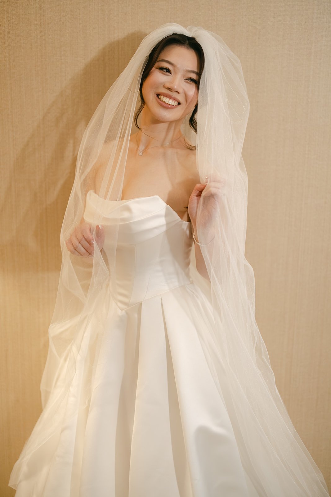 Bride smiling under her veil wearing soft glam bridal makeup by Tian Soon Makeup in Perth